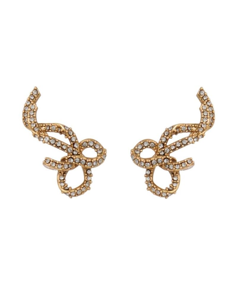 Brinco dourado estilo ear cuff em formato de laço com aplicações de cristal e banho ouro vintage, fotografado em fundo branco